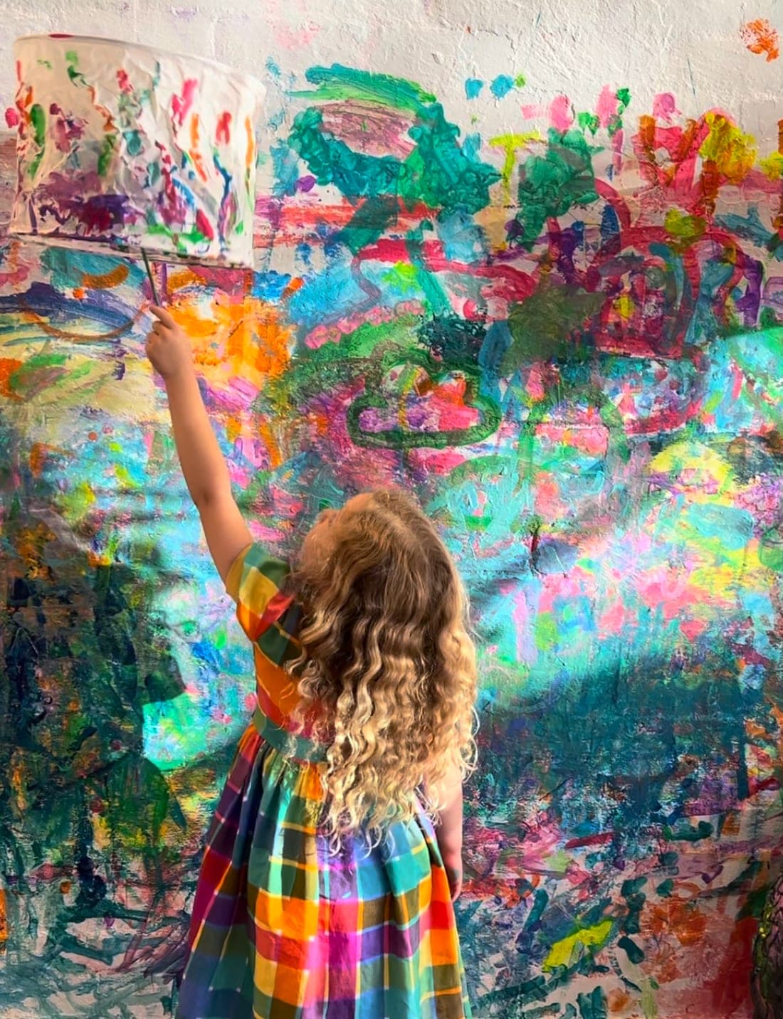 A child painting the studio wall at a Smudge party